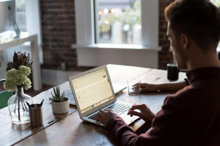 person typing on a laptop in a cozy home office setting